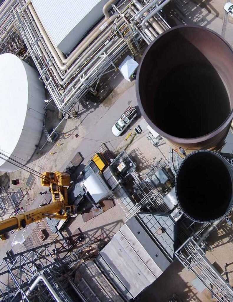 Aerial view of crane and large-diameter ducting during site installation at an industrial plant